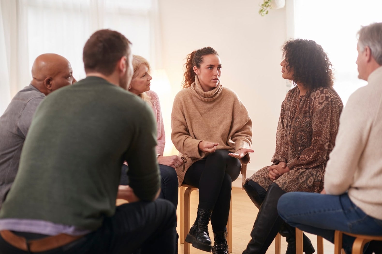 A facilitated discussion group seated in a circle, talking together
